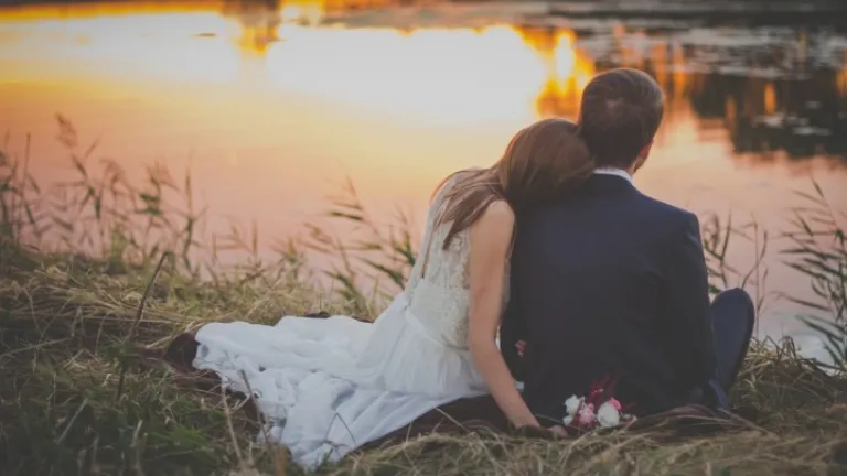 La compagnie est l’une des plus grandes bénédictions que puisse nous donner un mariage stable et aimant. C’est ce que Dieu reconnut en nous créant. Un jeune couple marié sont assis au bord d'un lac au coucher du soleil